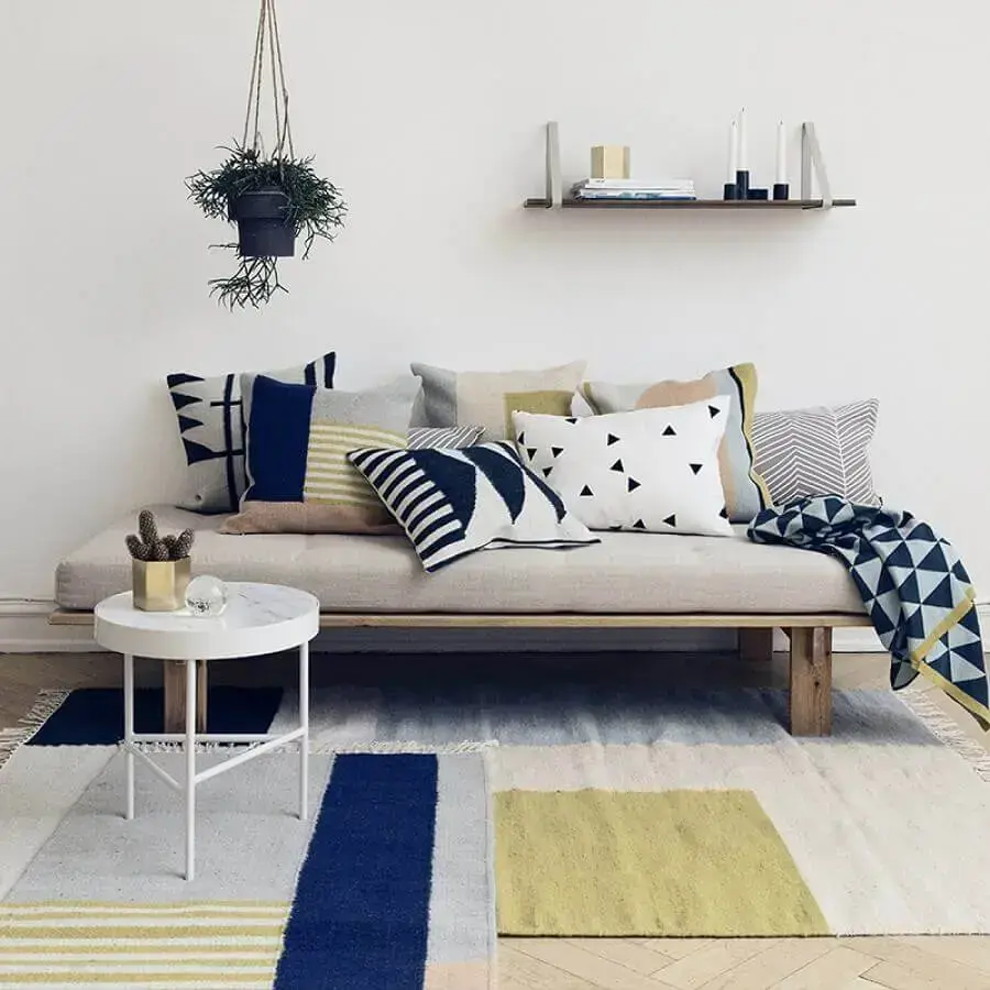 decoração minimalista para sala com tapetes coloridos muitas almofadas e manta para sofá Foto Royal Design