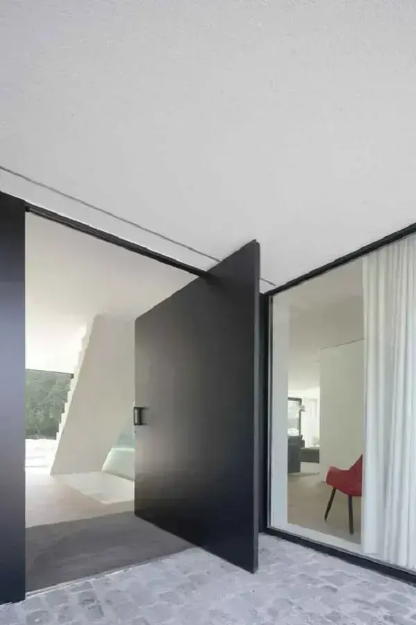 Decoração minimalista com porta pivotante preta