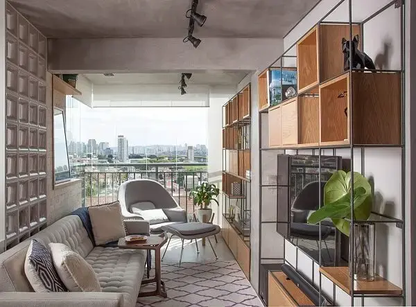 Ambiente compacto decorado com estante metálicas e poltrona cinza claro Ambiente compacto decorado com estante metálicas e poltrona cinza claro