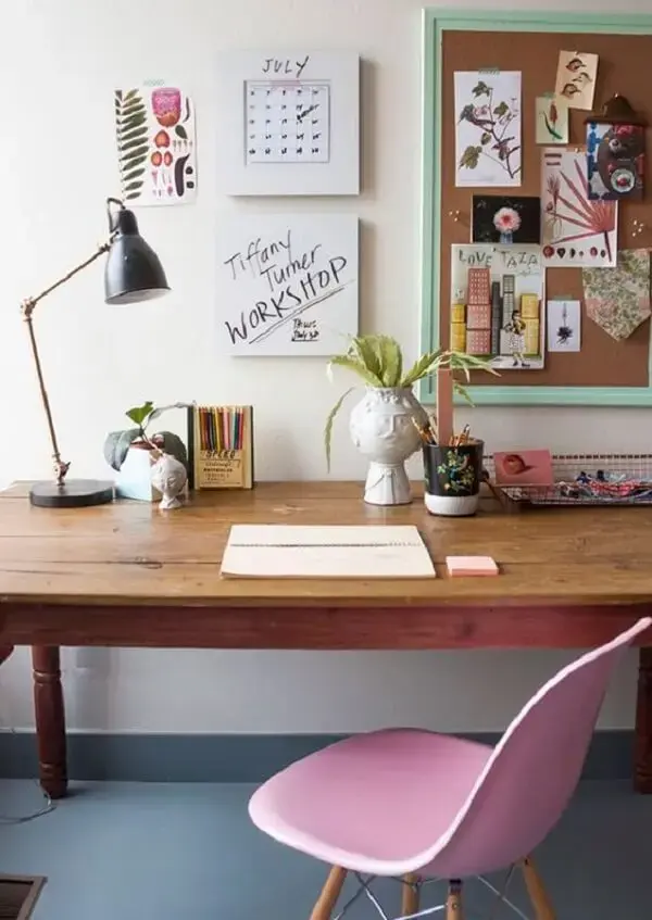 Decoração minimalista com mesa de madeira e quadro de cortiça na parede
