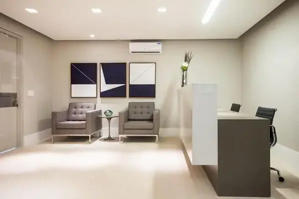 Escritório com quadros decorativos e poltrona cinza Escritório com quadros decorativos e poltrona cinza