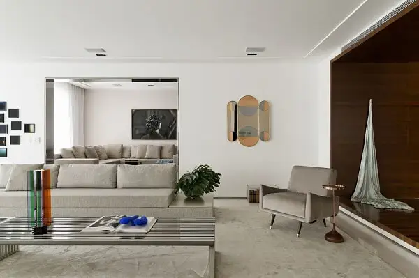 Poltrona cinza claro aveludada decora o ambiente dessa residência Poltrona cinza claro aveludada decora o ambiente dessa residência