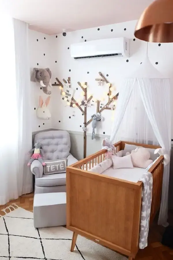 Quarto de bebê com árvore de madeira e poltrona cinza de amamentação Quarto de bebê com árvore de madeira e poltrona cinza de amamentação