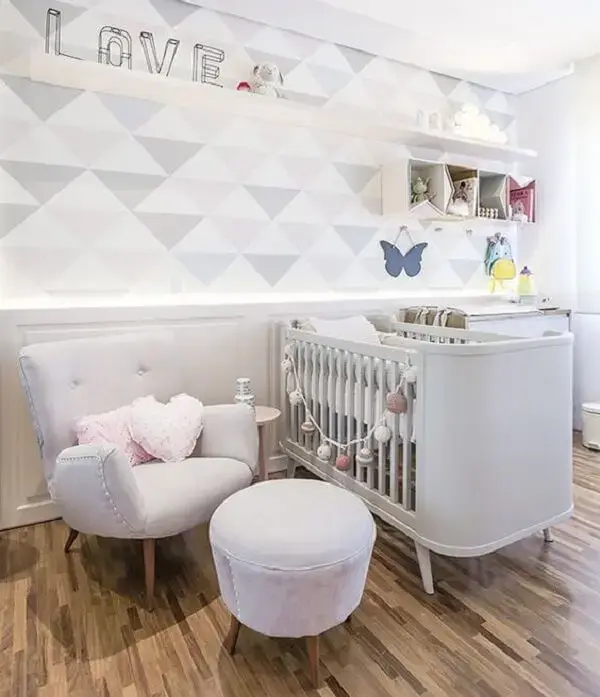 Quarto de bebê decorado com papel de parede geométrico e poltrona cinza de amamentação Quarto de bebê decorado com papel de parede geométrico e poltrona cinza de amamentação