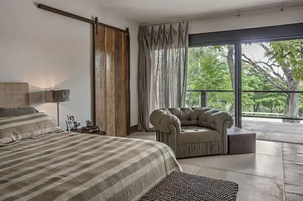 Quarto de casal amplo com poltrona cinza em capitonê Quarto de casal amplo com poltrona cinza em capitonê