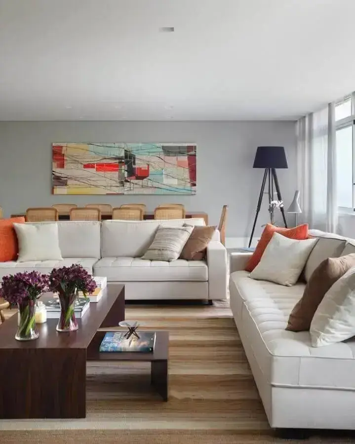 jogo de sofá branco para sala decorada com tapete listrado e quadro colorido jogo de sofá branco para sala decorada com tapete listrado e quadro colorido Foto Adriana Valle Patrícia Carvalho