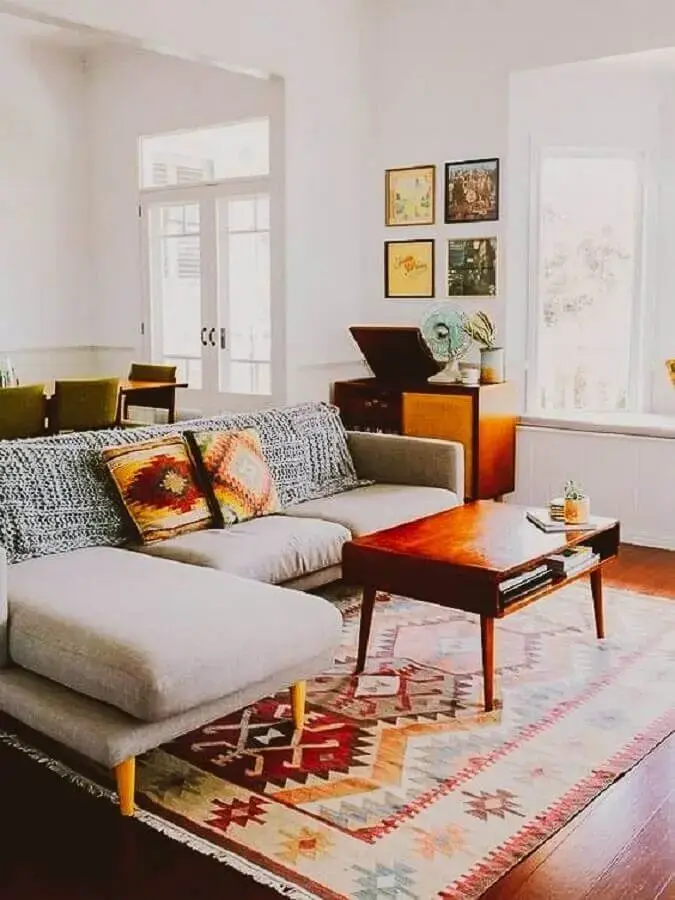 tapete para sala simples decorada com sofá com chaise e mesa de centro de madeira tapete para sala simples decorada com sofá com chaise e mesa de centro de madeira Foto A Casa Delas