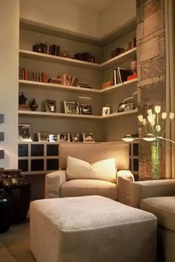 Decoração de sala de estar com estante de canto decorada com porta retratos e livros Decoração de sala de estar com estante de canto decorada com porta retratos e livros