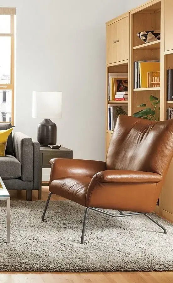 Poltrona confortável de couro para decoração de sala com estante de madeira e sofá cinza Poltrona confortável de couro para decoração de sala com estante de madeira e sofá cinza Foto Room & Board
