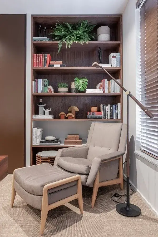 Poltrona confortável para leitura em sala decorada com estante de nichos Poltrona confortável para leitura em sala decorada com estante de nichos Foto VOA Arquitetura