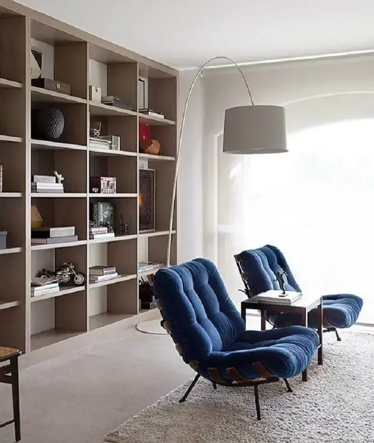 Poltrona confortável para sala decorada com estante de nichos e luminária de piso Poltrona confortável para sala decorada com estante de nichos e luminária de piso Foto Pinterest