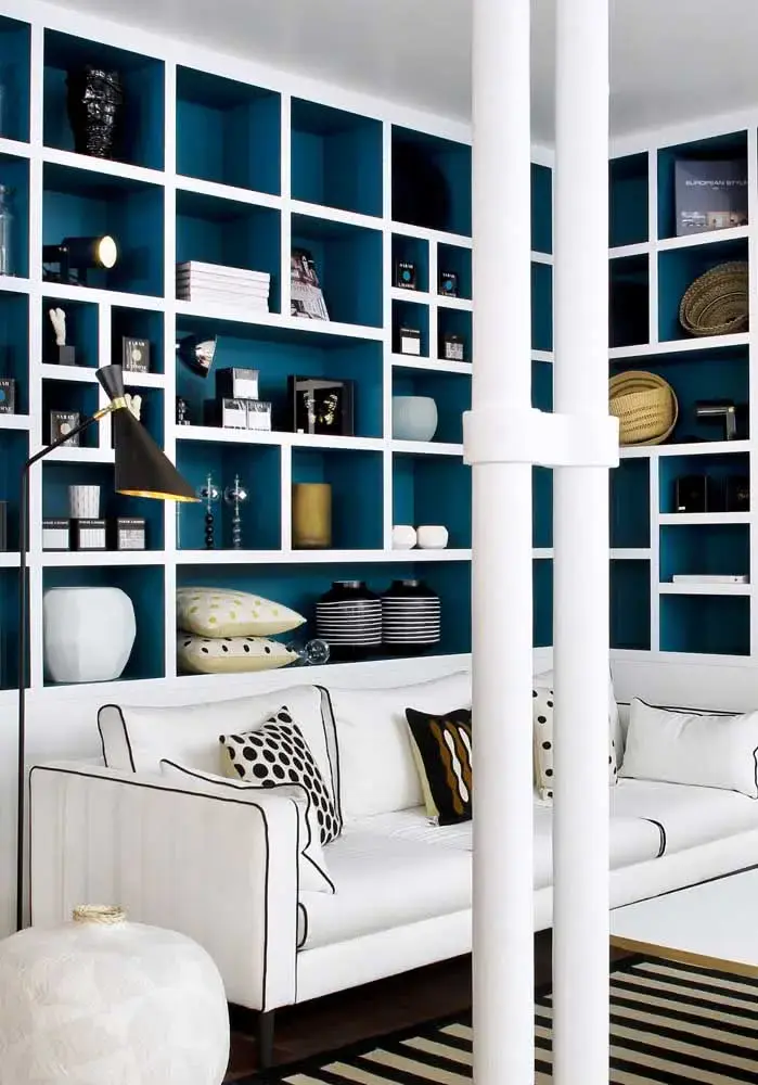 Sofá branco com estante de canto planejada em azul Sofá branco com estante de canto planejada em azul