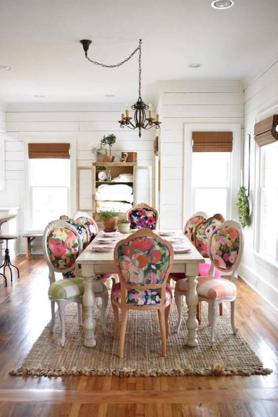 Sala grande decorada com mesa e cadeiras vintage coloridas e florais