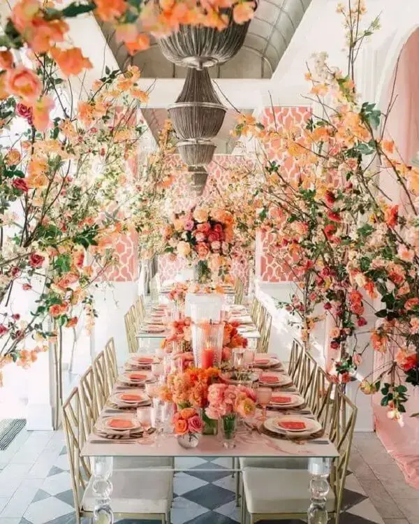 Mesa de jantar com flores coloridas e decoração cor coral
