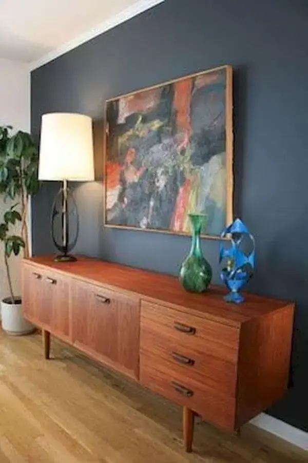 Rack minimalista de madeira rustica na decoração em azul marinho e vasos coloridos