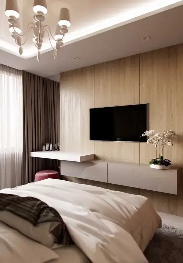 Rack minimalista para quarto planejado com painel para tv e vaso de flores na decoração