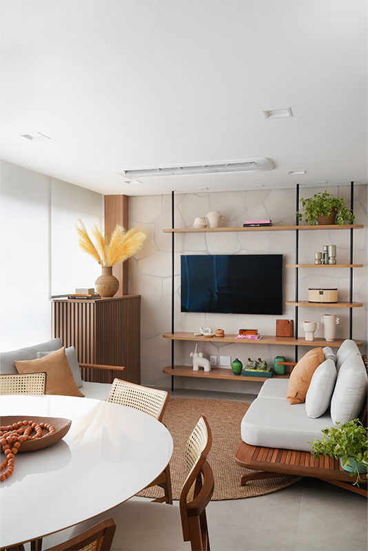 Projeto: Rosangela Pena Arquitetura | Serralheria e madeira se unem na parede para formar uma estante minimalista que dá leveza à TV, fixada em um painel de porcelanato orgânico instalado peça por peça