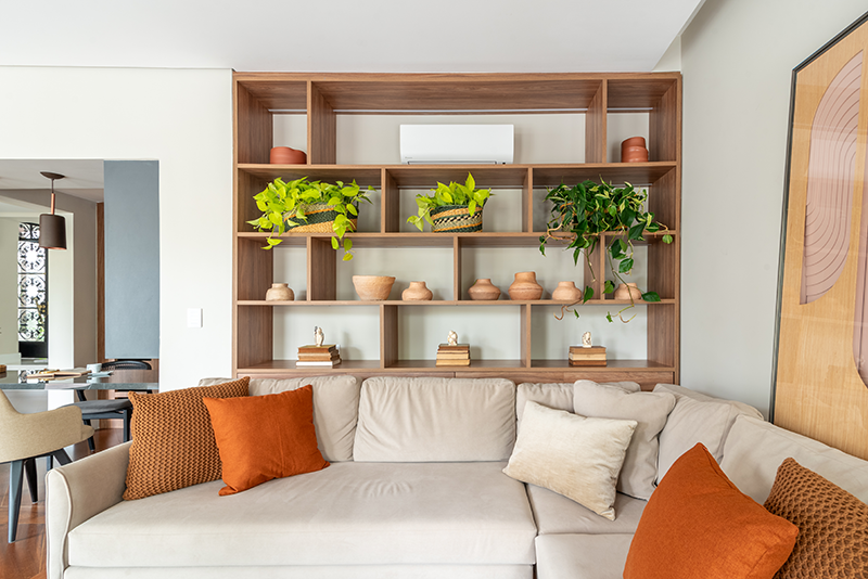 Projeto: Isabella Nalon | Neste ambiente, o ar-condicionado foi discretamente integrado ao nicho superior da estante. A composição com elementos decorativos suaviza sua presença e harmoniza o equipamento ao décor.