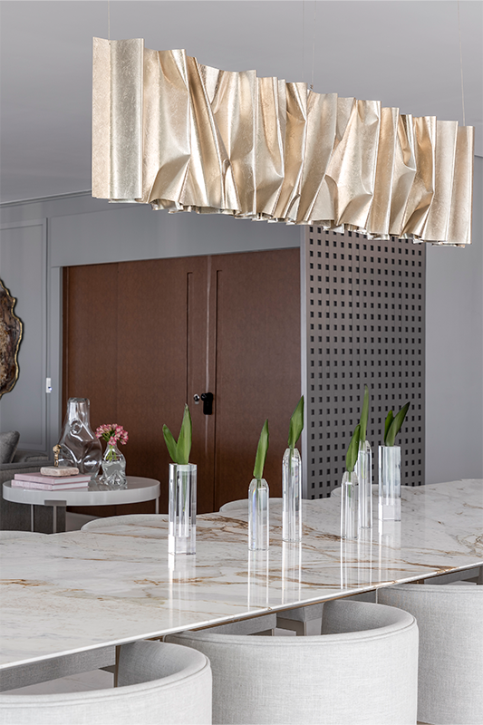 Projeto: Spaço Interior - Ana Rozenblit | Com personalidade e elegância, a sala de jantar ganha destaque com o pendente Altomare, da Scatto Lampadário, uma escultura de alumínio esculpido à mão que ilumina o ambiente com impacto.