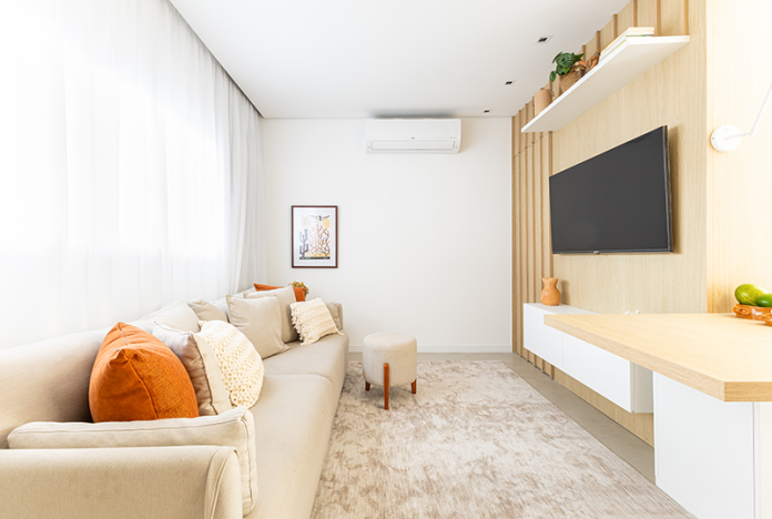 Projeto: Bimá Arquitetura | Sala de TV com atmosfera acolhedora e tons neutros que transmitem conforto e leveza. O destaque vai para o painel amadeirado e os toques terrosos nos detalhes, que aquecem o ambiente e criam uma composição equilibrada e elegante