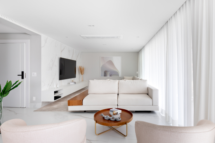 Sofá branco e porcelanato marmorizado criam um visual leve e elegante – Foto: @vitorguilherme.interiores | Projeto: Natália Barsô Arquitetura e Interiores