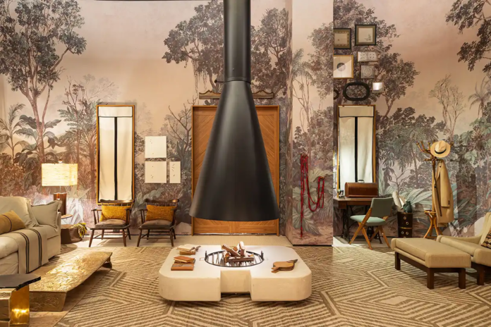 7. Papel de parede de floresta transforma a sala em um refúgio elegante – Foto: Camila Santos/CASACOR | Projeto: Carol Miluzzi Arquitetura