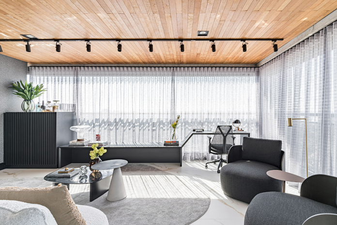 Com grande demanda de uso, este home office foi constituído como um cômodo independente, embora esteja presente na varanda, integrado com a sala.