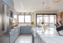 Juntas, porém delimitadas: a importância da oferecer a independência entre a cozinha e a área de serviço nos projetos residenciais Projeto Mari Milani| Cozinha ampla com ilha central e marcenaria em azul claro. A área de serviço fica integrada, mas discreta, graças à porta de serralheria com vidro canelado, garantindo luz natural e organização.