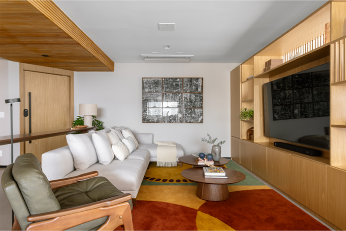 Sala de estar privilegia tons e acabamentos acolhedores, como o tapete Colheita by Vanessa Ribeiro para a Coleção Decoralle e Mazco