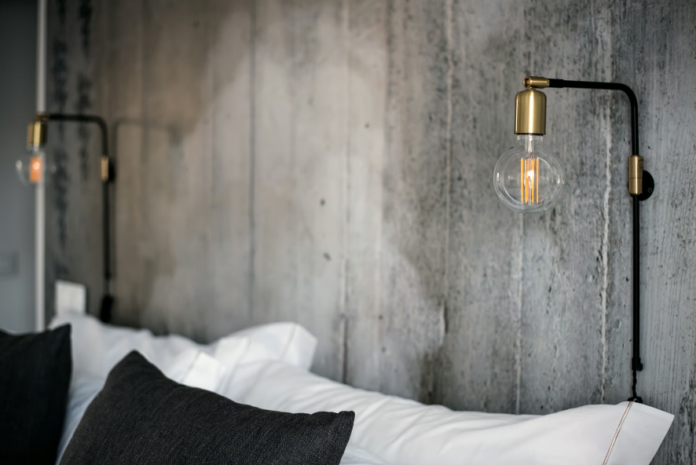 Arandela articulada acima da cabeceira libera a mesa lateral e direciona a luz – Foto: Envato