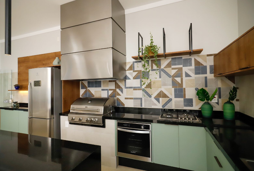 Porcelanato e azulejo podem ser usados para revestir a parede de fundo e as laterais próximas da cozinha com churrasqueira – Foto: Rina Gallo | Projeto: Maria Ignez Arquitetura